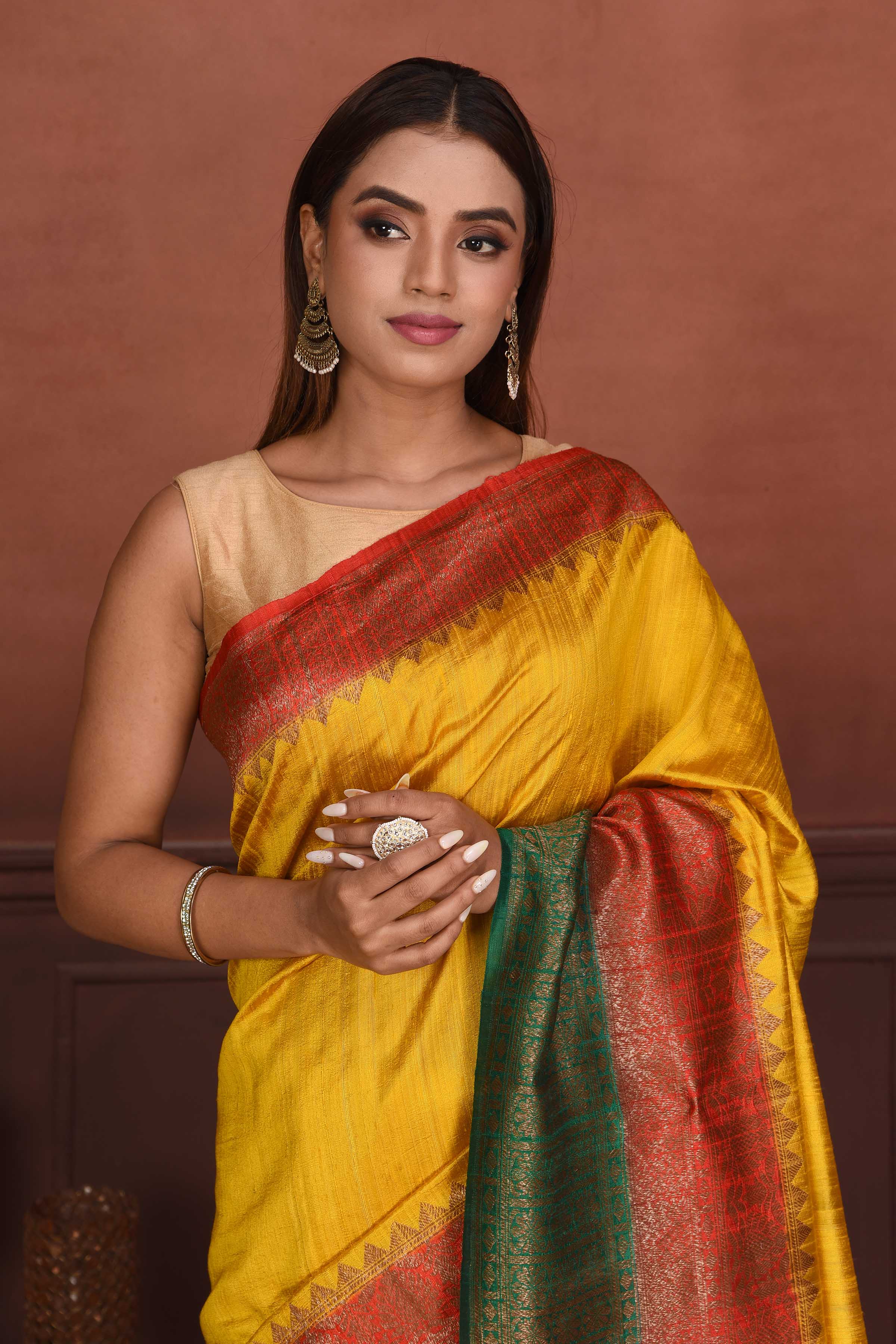 Shop yellow tussar Banarasi saree online in USA with red green zari border. Look your best on festive occasions in latest designer sarees, pure silk sarees, Kanchipuram silk sarees, handwoven sarees, tussar silk sarees, embroidered sarees from Pure Elegance Indian clothing store in USA.-closeup