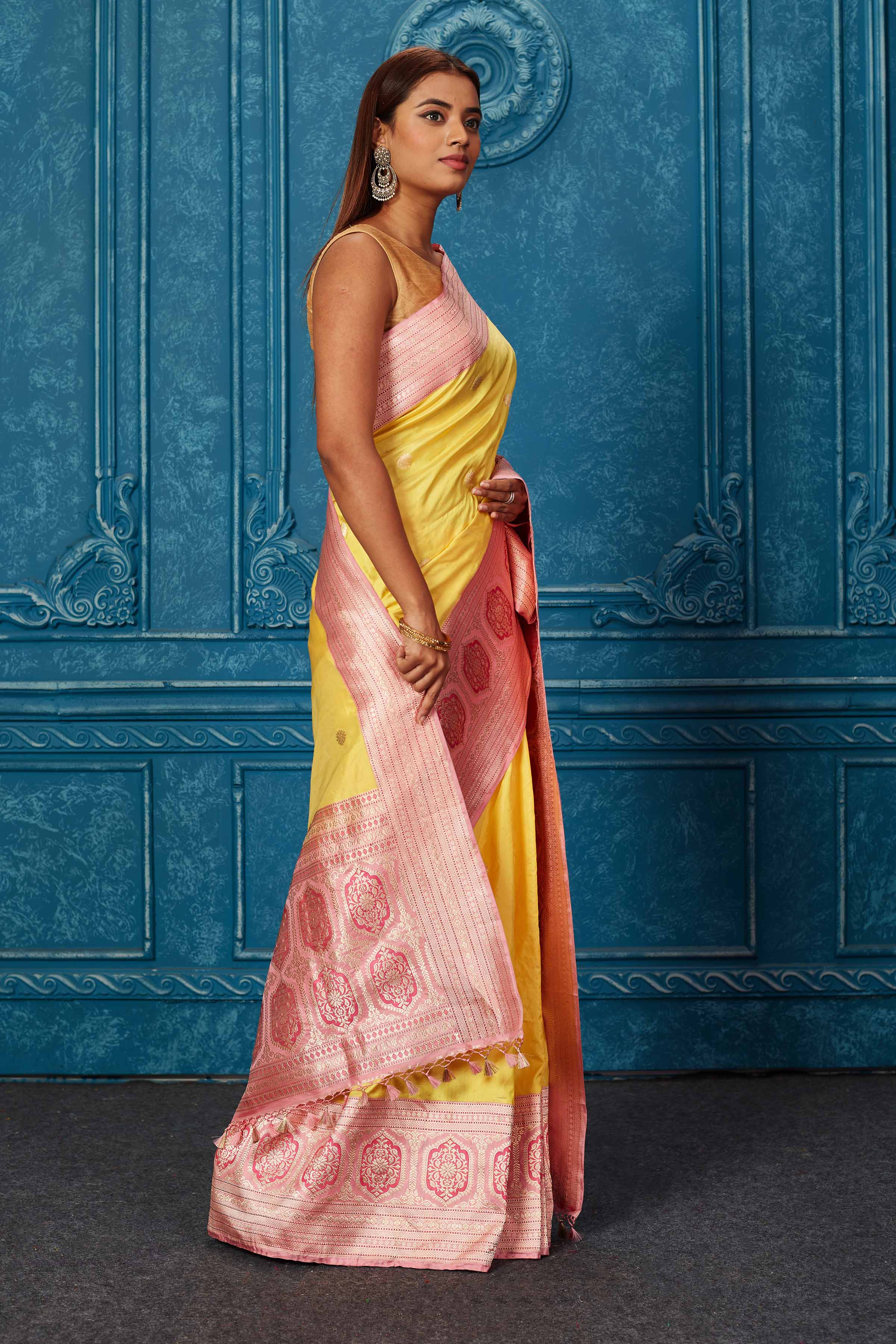 Shop yellow Banarasi saree online in USA with pink zari border. Look your best on festive occasions in latest designer sarees, pure silk saris, Kanchipuram silk sarees, handwoven sarees, tussar silk sarees, embroidered sarees from Pure Elegance Indian saree store in USA.-side