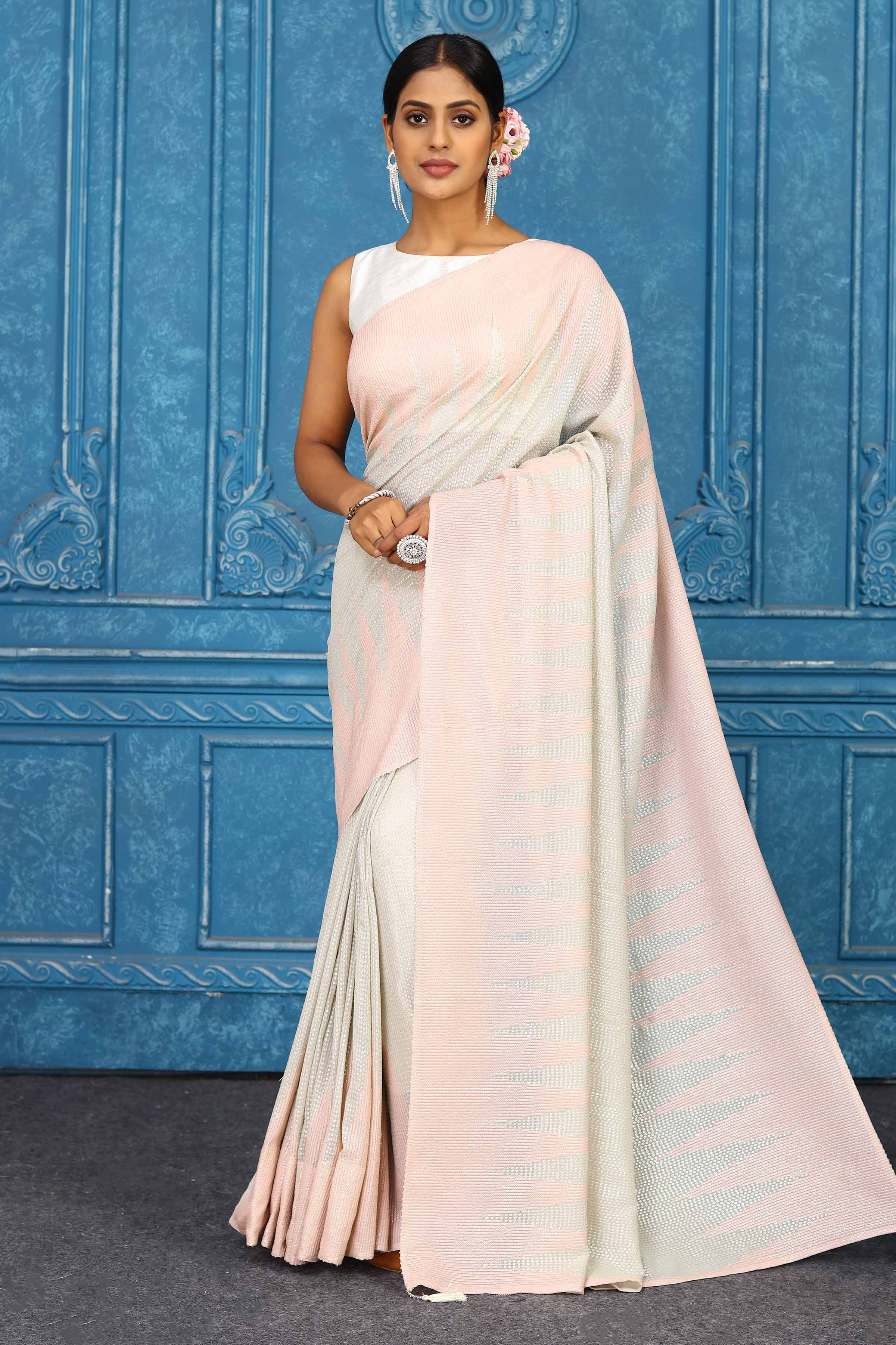 Buy beautiful baby pink georgette sequin saree online in USA with temple border. Look your best on festive occasions in latest designer sarees, pure silk sarees, Kanchipuram sarees, handwoven sarees, tussar silk sarees, embroidered sarees from Pure Elegance Indian clothing store in USA.-full view