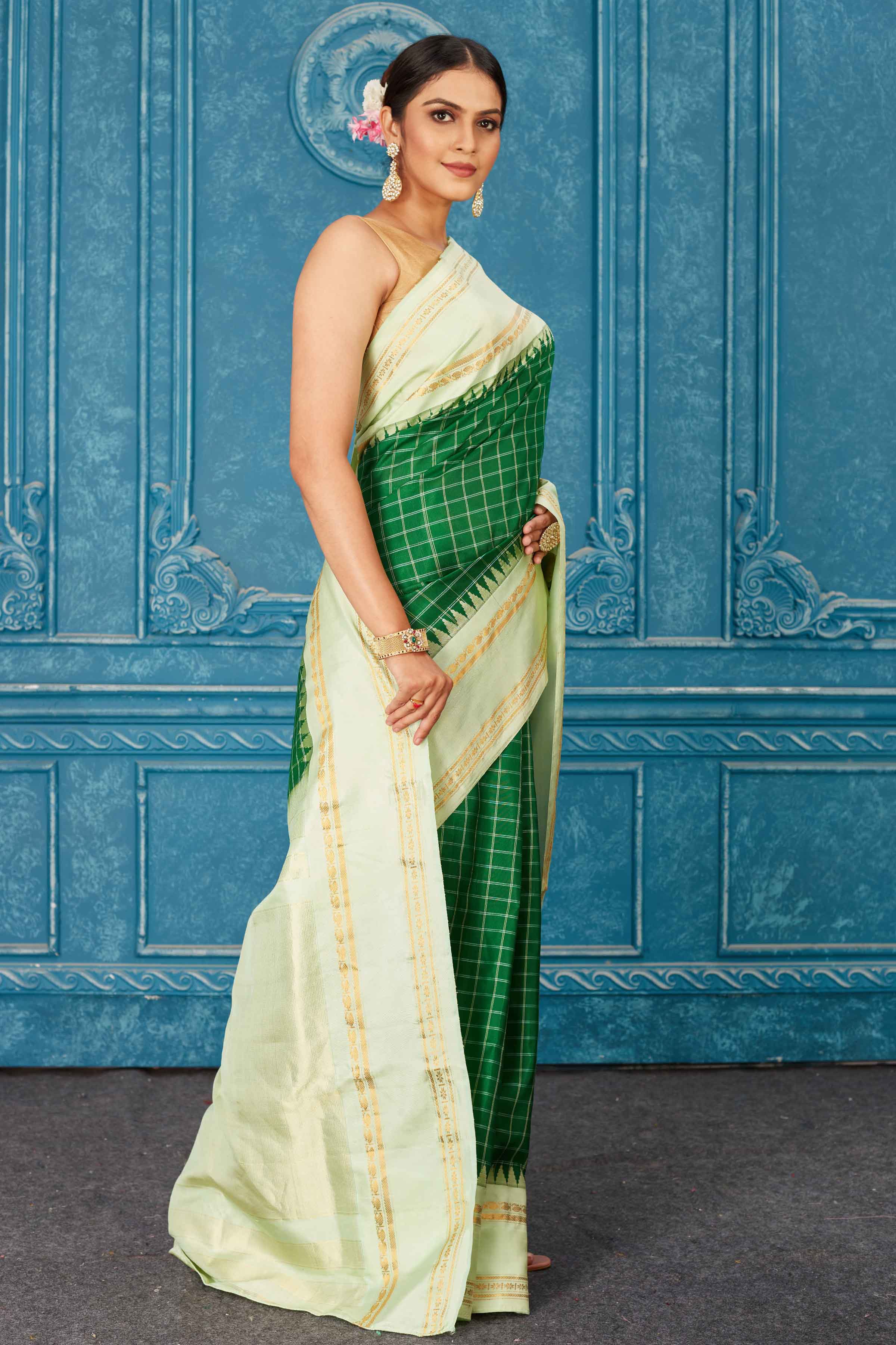 Buy stunning green Kanchipuram silk saree online in USA with mint green border. Radiate glam at parties in dazzling designer sarees, party sarees, embroidered sarees, sequin work sarees, Bollywood sarees, handloom sarees from Pure Elegance Indian saree store in USA.-side