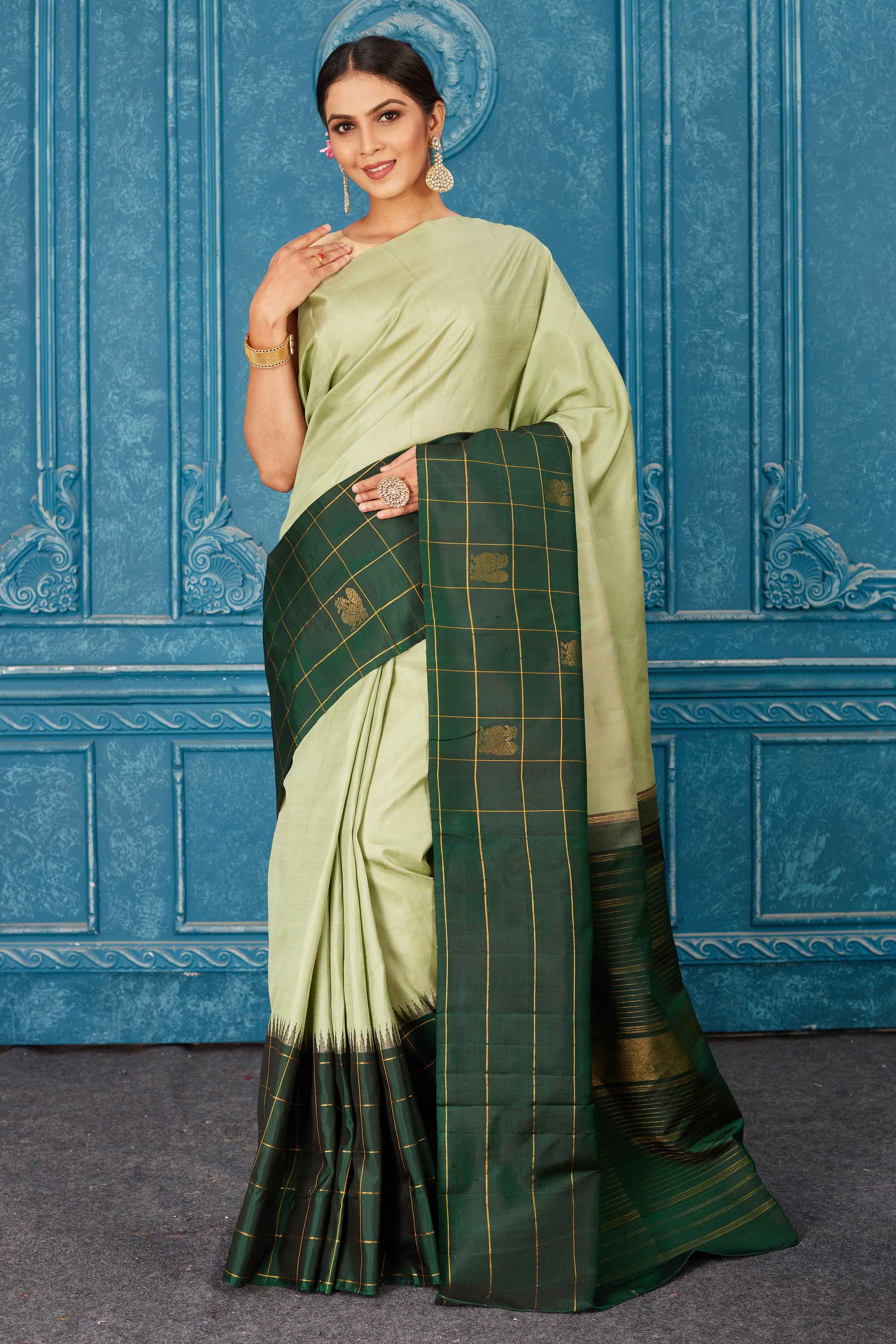 Buy beautiful pista green Gadhwal silk saree online in USA with dark green check border. Radiate glam at parties in dazzling designer sarees, party sarees, embroidered sarees, sequin work sarees, Bollywood sarees, handloom sarees from Pure Elegance Indian saree store in USA.-front