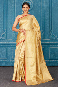 Buy beautiful golden Kanjeevaram silk sari online in USA with red edging. Radiate glam at parties in dazzling designer sarees, party sarees, embroidered sarees, sequin work sarees, Bollywood sarees, handloom sarees from Pure Elegance Indian saree store in USA.-full view