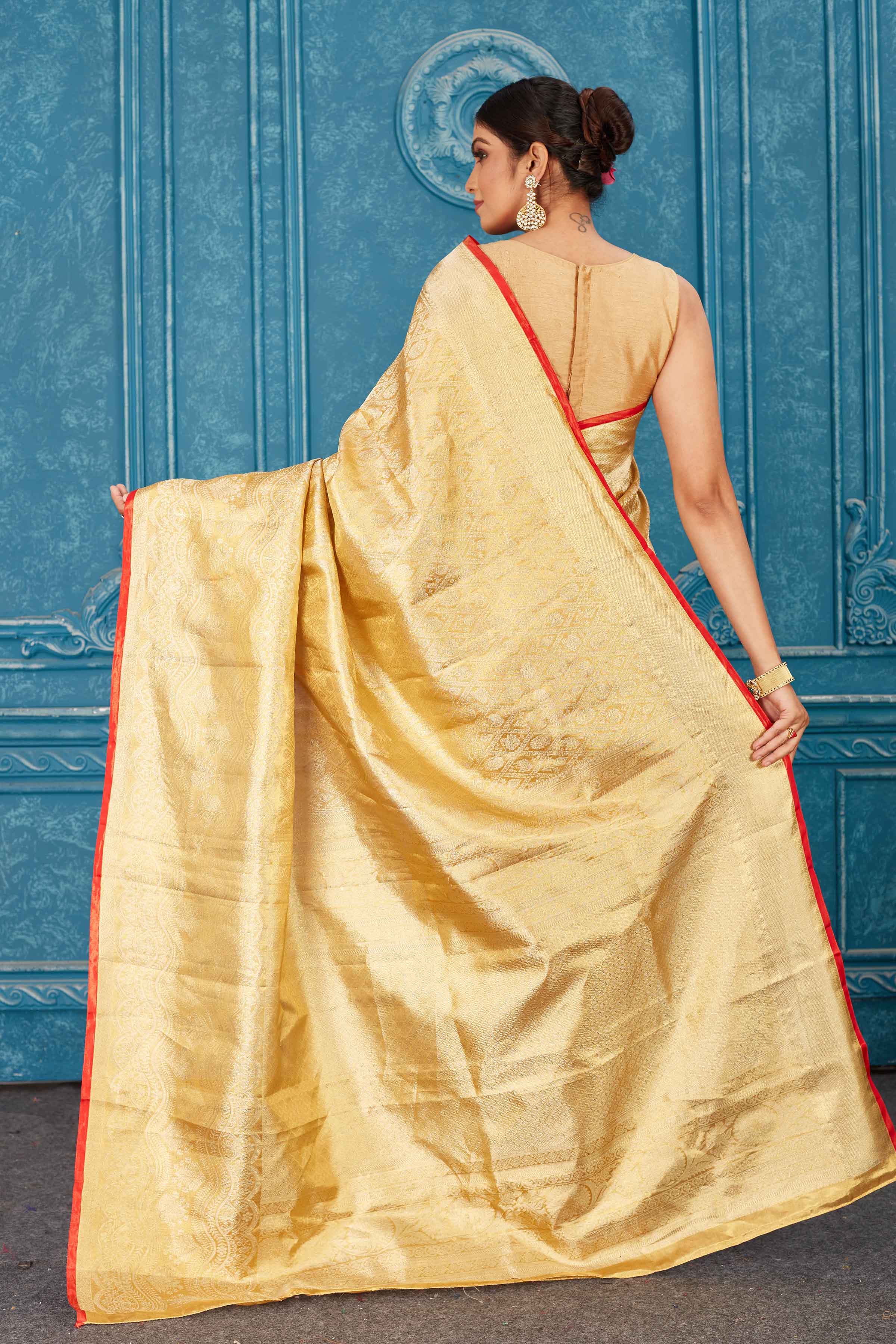 Buy beautiful golden Kanjeevaram silk sari online in USA with red edging. Radiate glam at parties in dazzling designer sarees, party sarees, embroidered sarees, sequin work sarees, Bollywood sarees, handloom sarees from Pure Elegance Indian saree store in USA.-back