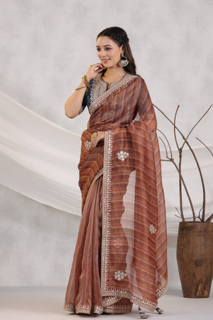 Buy brown striped organza saree online in USA with blue embroidered blouse. Make a fashion statement on festive occasions and weddings with designer suits, Indian dresses, Anarkali suits, palazzo suits, designer sarees, sharara suits, Bollywood saris from Pure Elegance Indian fashion store in USA.-front