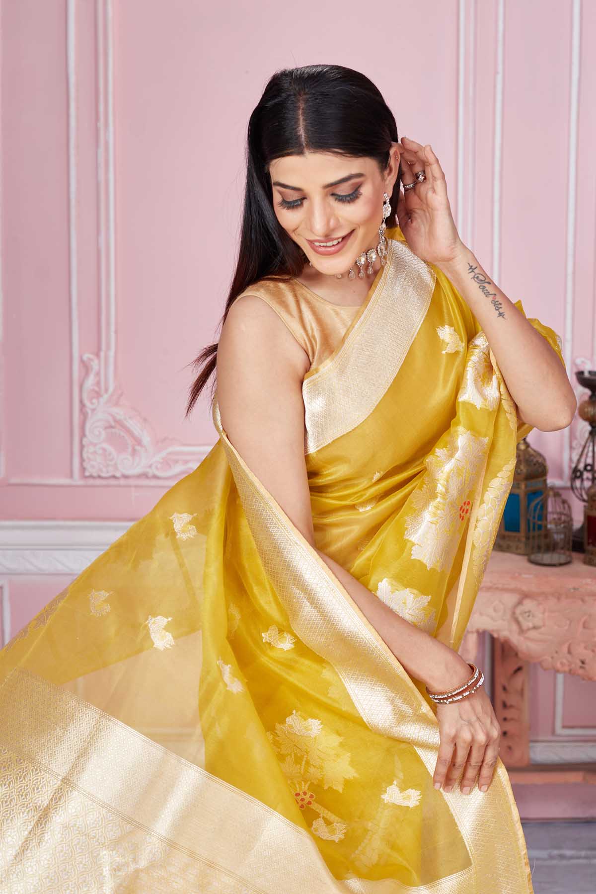 Buy beautiful yellow Banarasi sari online in USA with golden zari border and pallu. Look your best on festive occasions in latest designer saris, pure silk sarees, Kanjivaram silk sarees, handwoven saris, tussar silk sarees, embroidered saris from Pure Elegance Indian fashion store in USA.-closeup