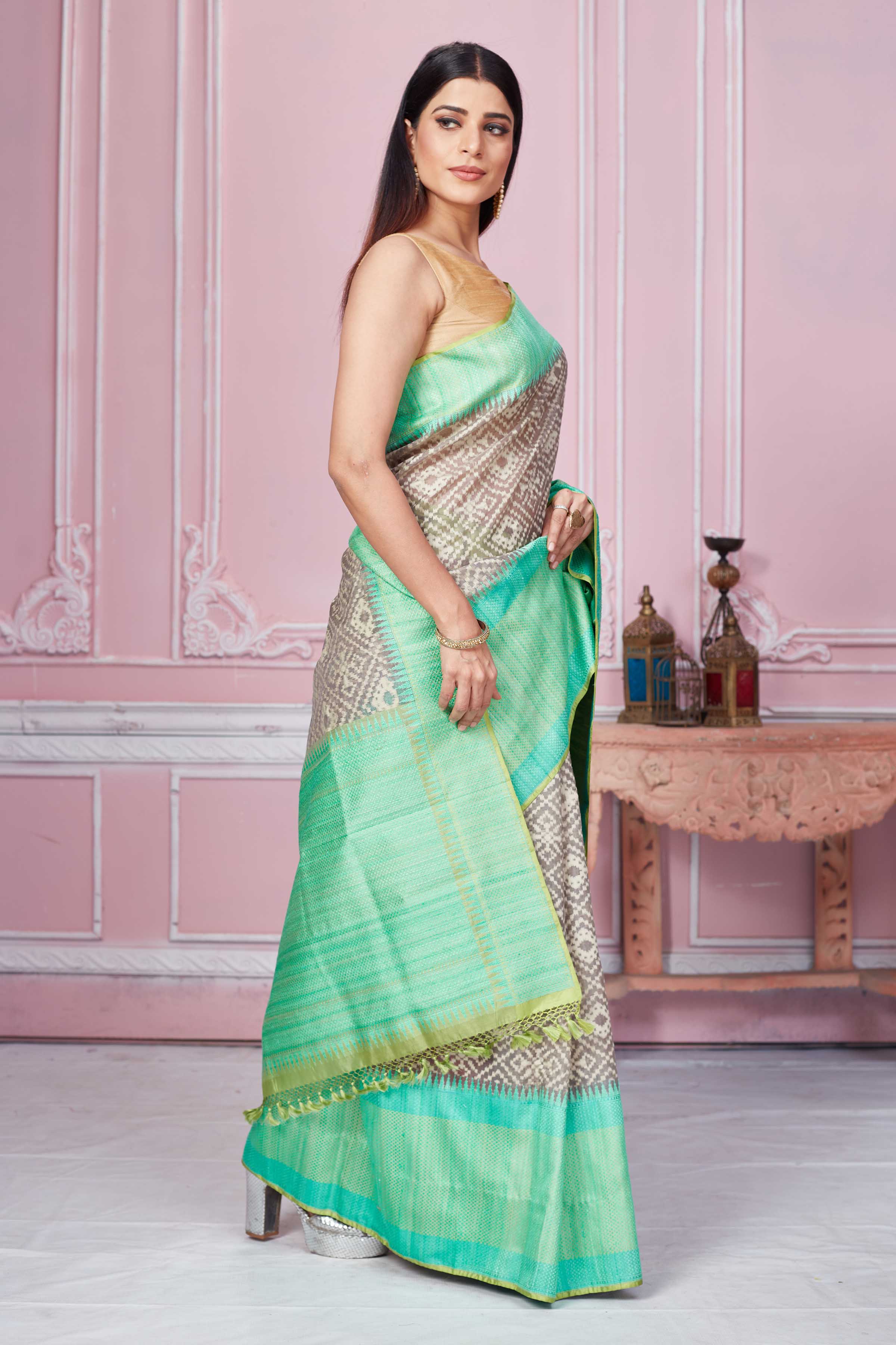 Shop grey Kora Banarasi saree online in USA with green border and pallu. Look your best on festive occasions in latest designer sarees, pure silk saris, Kanchipuram silk sarees, handwoven sarees, tussar silk saris, embroidered sarees from Pure Elegance Indian fashion store in USA.-side
