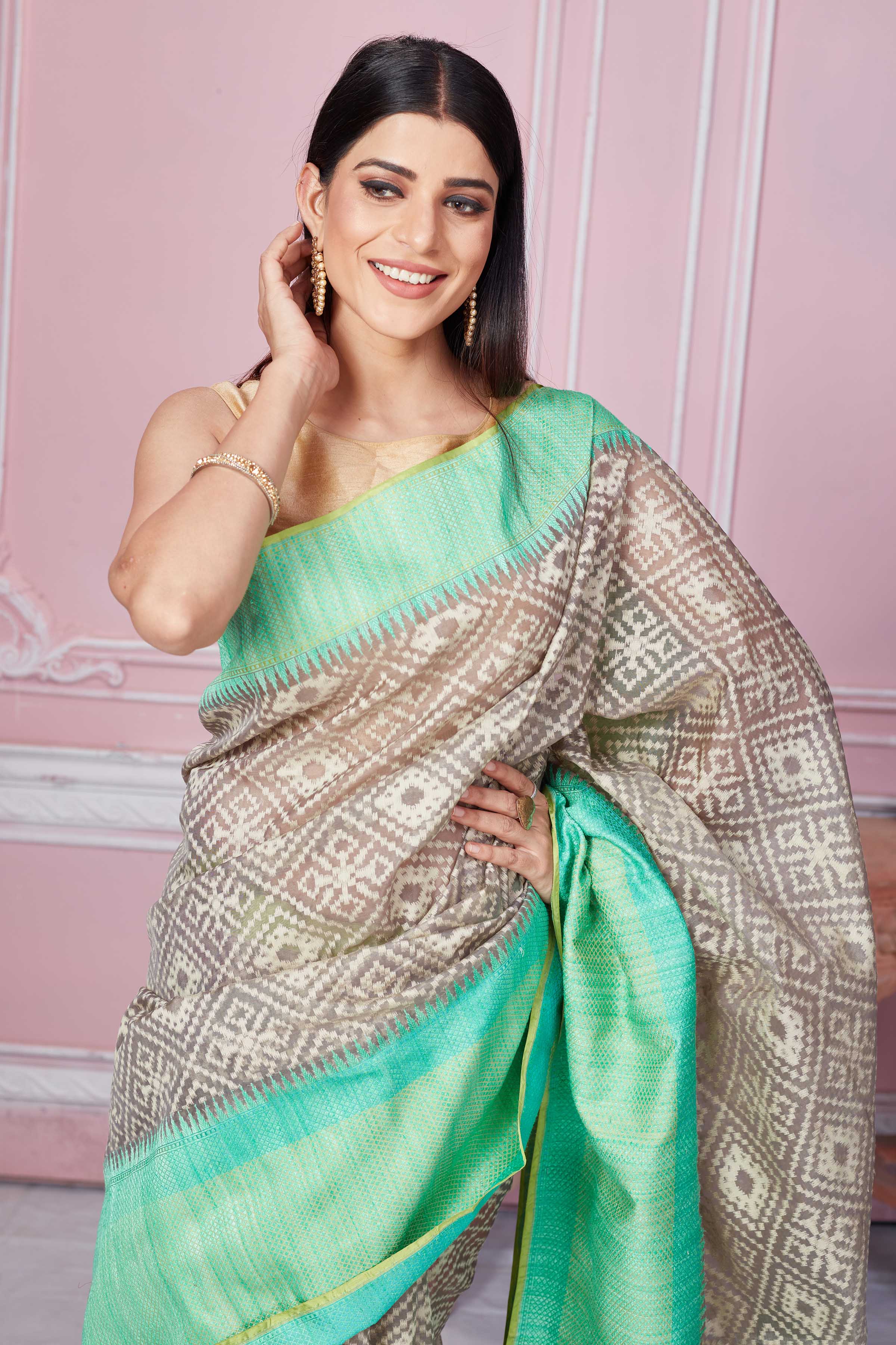 Shop grey Kora Banarasi saree online in USA with green border and pallu. Look your best on festive occasions in latest designer sarees, pure silk saris, Kanchipuram silk sarees, handwoven sarees, tussar silk saris, embroidered sarees from Pure Elegance Indian fashion store in USA.-closeup