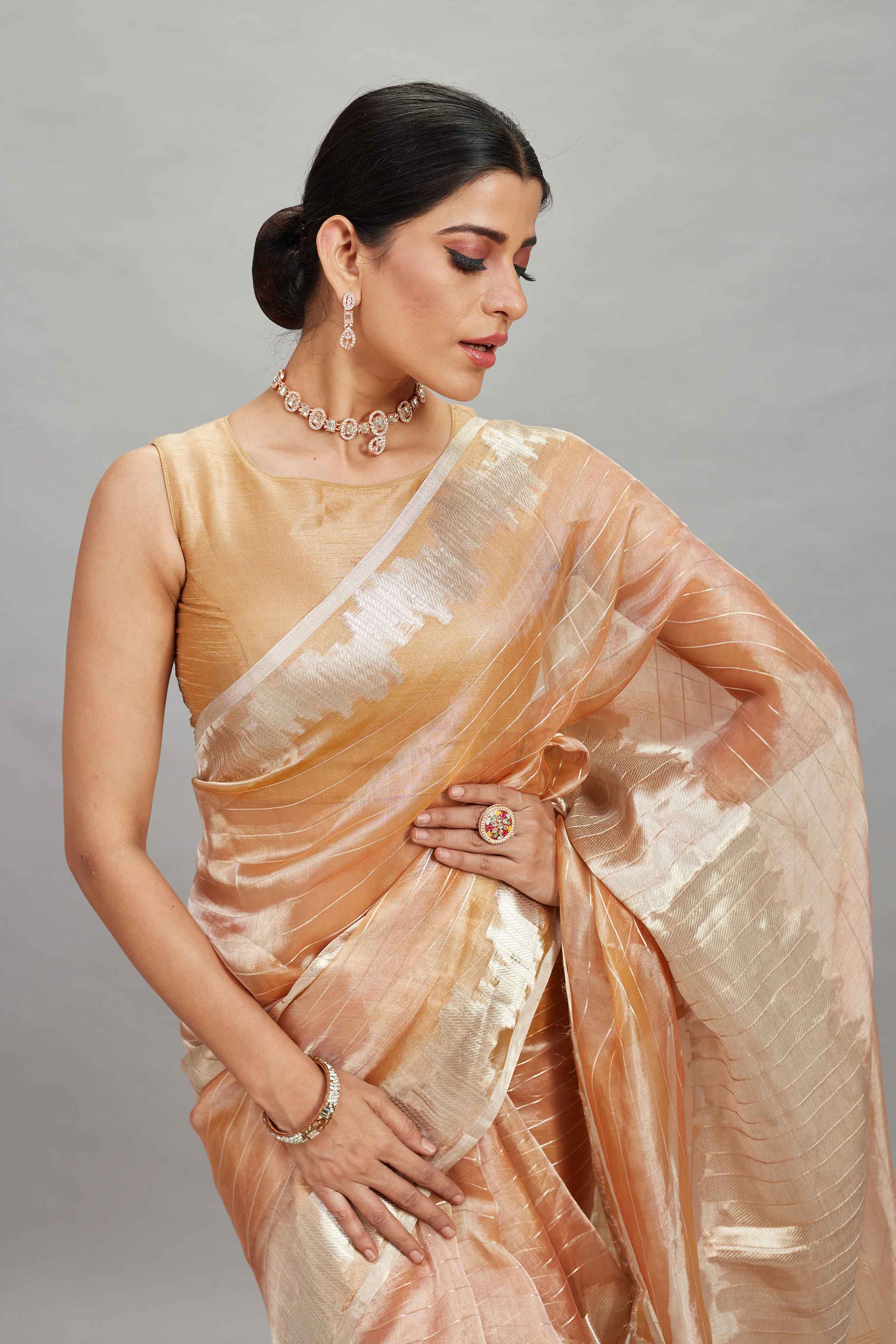 Shop peach and silver striped tissue Banarasi saree online in USA. Look your best on festive occasions in latest designer sarees, pure silk sarees, Kanjivaram silk saris, handwoven saris, tussar silk sarees, embroidered saris from Pure Elegance Indian clothing store in USA.-closeup