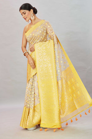 Shop cream Kora Banarasi sari online in USA with heavy yellow border. Look your best on festive occasions in latest designer sarees, pure silk sarees, Kanjivaram silk saris, handwoven saris, tussar silk sarees, embroidered saris from Pure Elegance Indian clothing store in USA.-pallu