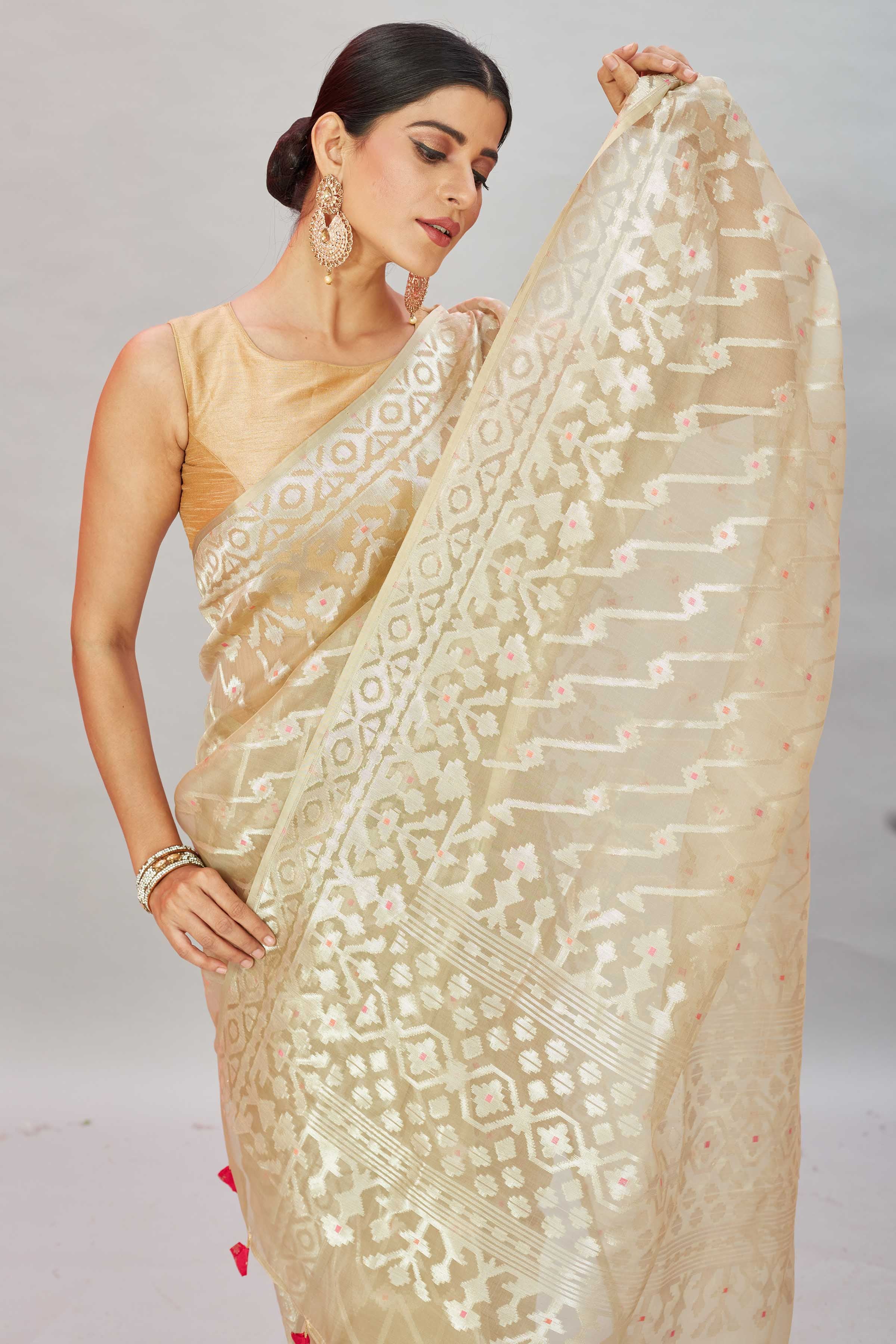 Buy cream Kora Banarasi sari online in USA with overall zari work. Look your best on festive occasions in latest designer sarees, pure silk sarees, Kanjivaram silk saris, handwoven saris, tussar silk sarees, embroidered saris from Pure Elegance Indian clothing store in USA.-closeup