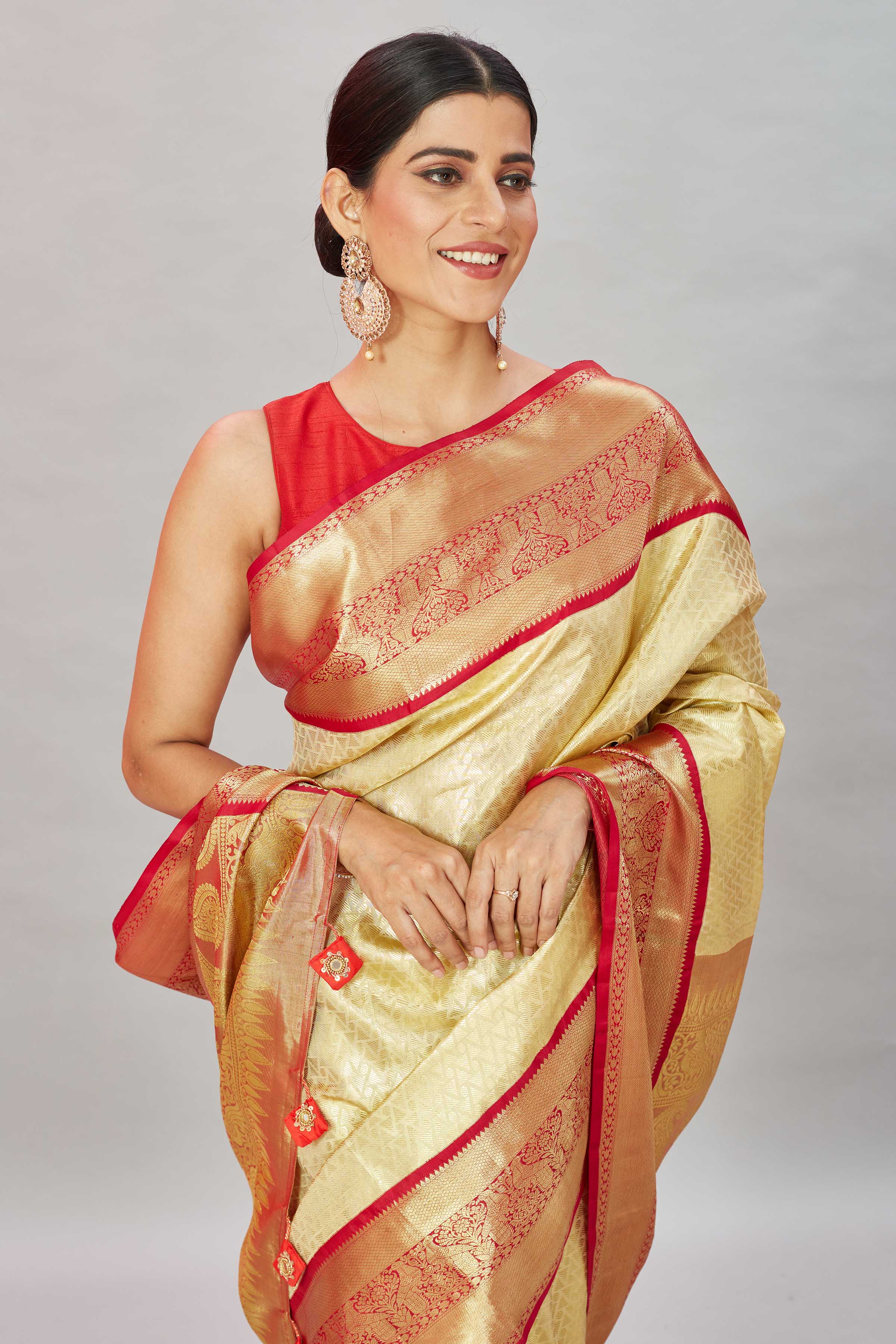 Buy cream Kanjivaram silk sari online in USA with red zari border. Look your best on festive occasions in latest designer sarees, pure silk sarees, Kanjivaram silk saris, handwoven saris, tussar silk sarees, embroidered saris from Pure Elegance Indian clothing store in USA.-closeup