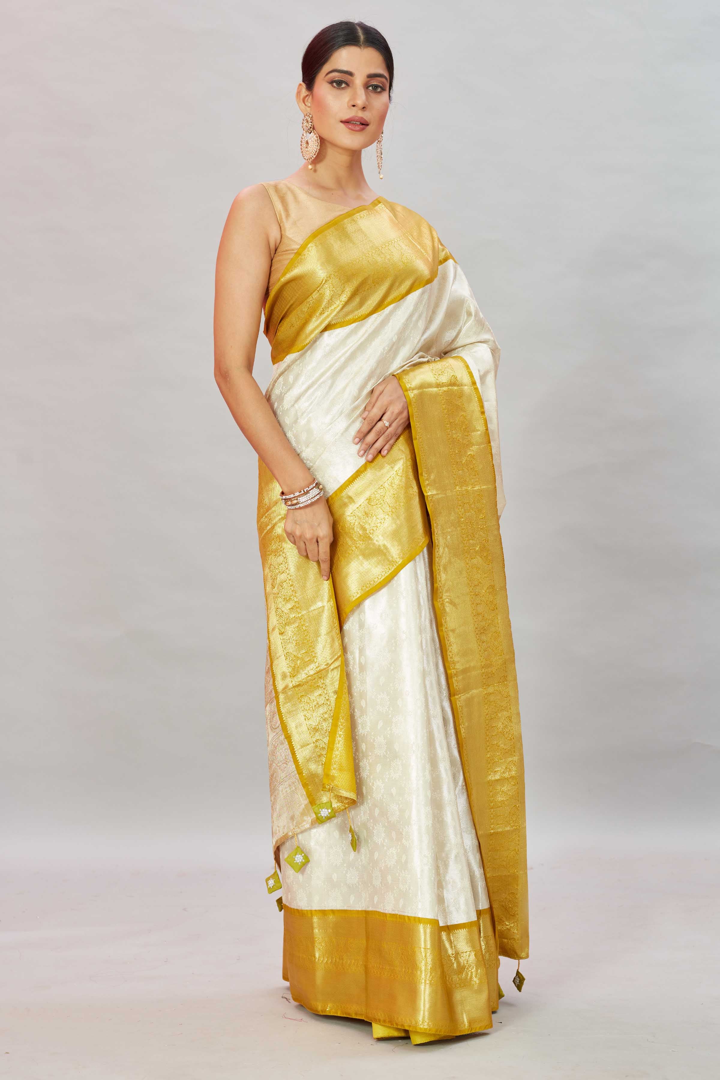 Shop cream Kanjivaram silk sari online in USA with golden zari border. Look your best on festive occasions in latest designer sarees, pure silk sarees, Kanjivaram silk saris, handwoven saris, tussar silk sarees, embroidered saris from Pure Elegance Indian clothing store in USA.-side