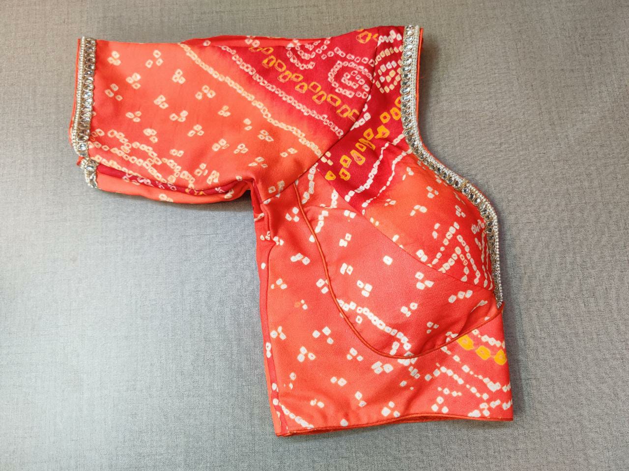 Shop stunning red Bandhej saree blouse online in USA with golden lace. Elevate your Indian ethnic saree looks with beautiful readymade saree blouse, embroidered saree blouses, Banarasi saree blouse, designer sari blouses, sleeveless saree blouses from Pure Elegance Indian fashion store in USA.-sleeves