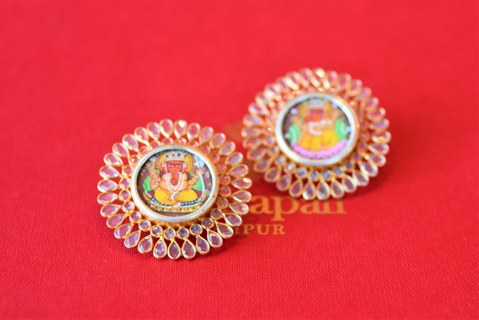 Buy Amrapali ethnic silver gold plated crystal studs online in USA with Lord Ganesha painting. Add spark to your ethnic attires with beautiful Indian silver gold plated jewelry, wedding jewelry, silver gold plated necklaces from Pure Elegance Indian fashion store in USA.-flatlay