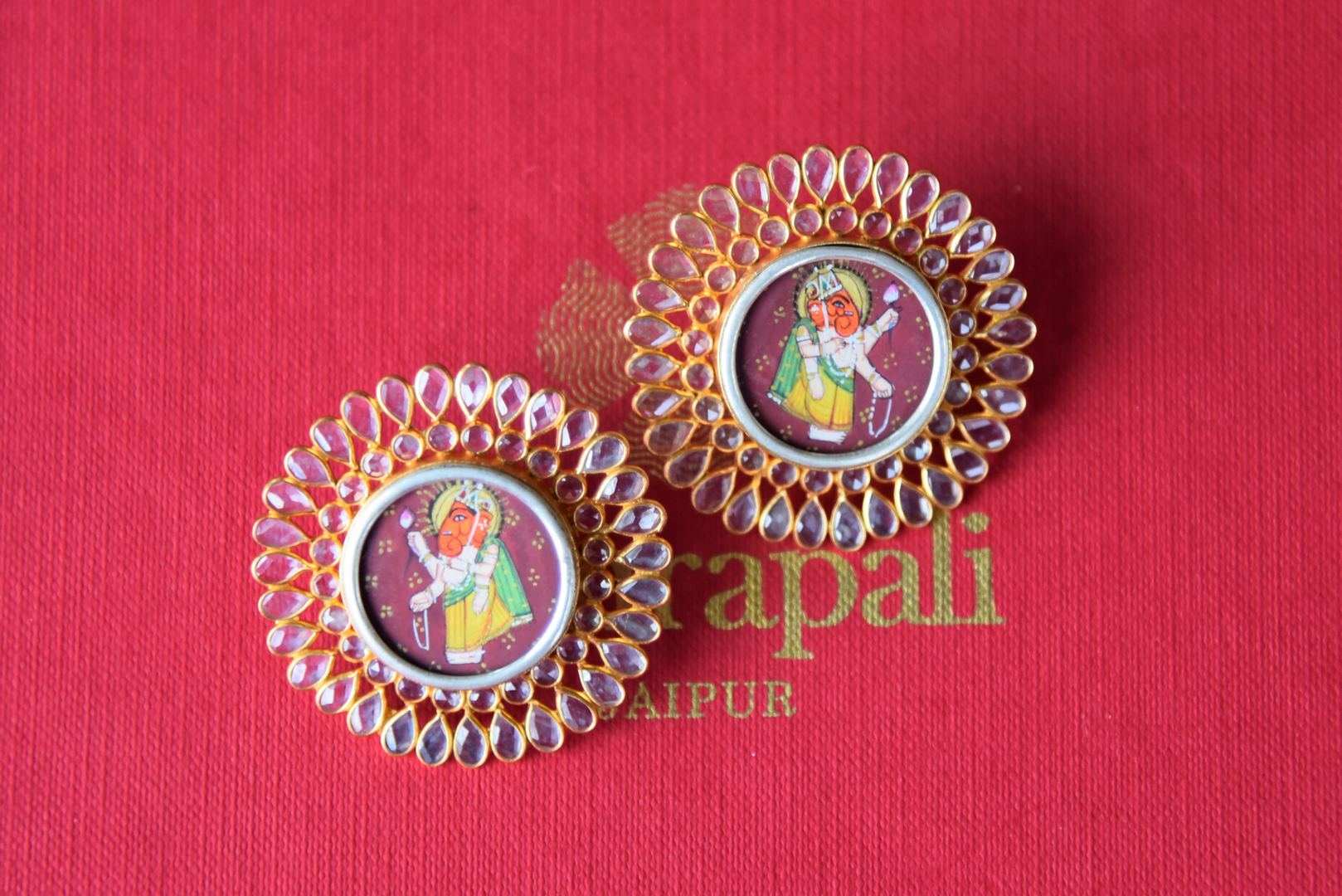 Shop silver gold plated floral Amrapali glass stud earrings online in USA with Lord Ganesha painting. Get festival ready with a range of exquisite handcrafted Indian silver gold plated jewelry from Pure Elegance Indian clothing store in USA.-flatlay