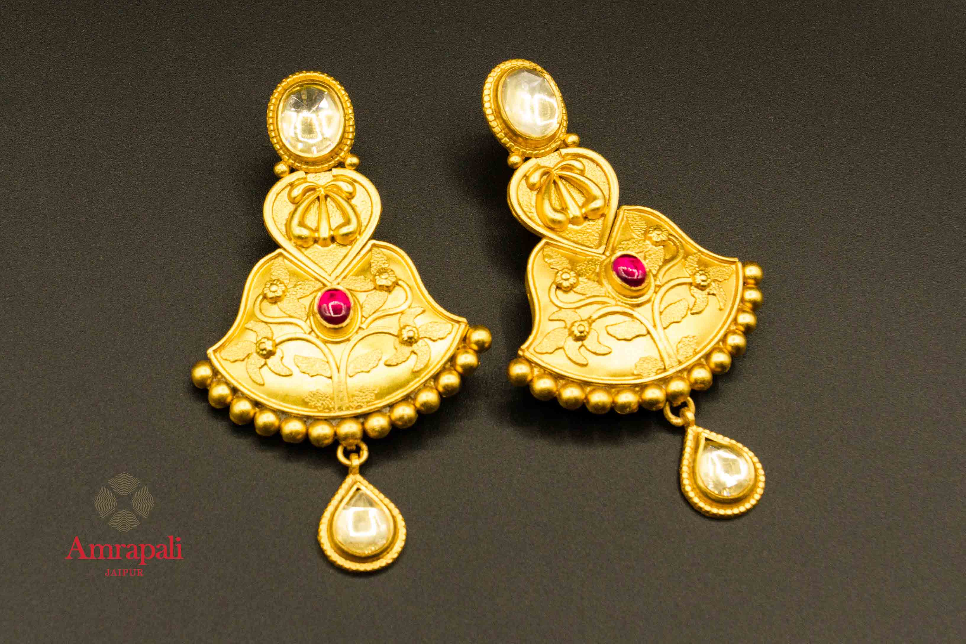 Buy Amrapali elegant silver gold plated glass earrings online in USA with red stone. Raise your traditional fashion quotient on special occasions with exquisite Indian jewelry from Pure Elegance Indian clothing store in USA. Enhance your look with silver gold plated jewelry, fashion jewelry available online.-flatlay