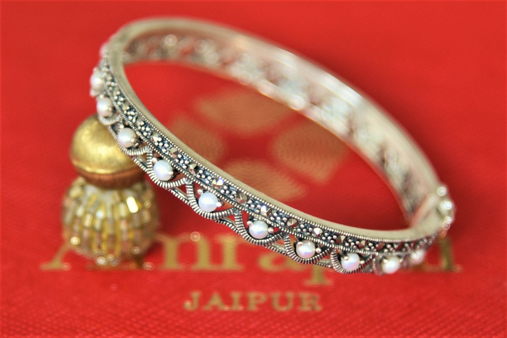 Buy Amrapali pearl silver bangle online in USA. Give yourself a beautiful traditional makeover this wedding season with exquisite gold plated jewellery, silver jewelry from Pure Elegance Indian fashion boutique in USA.-flatlay