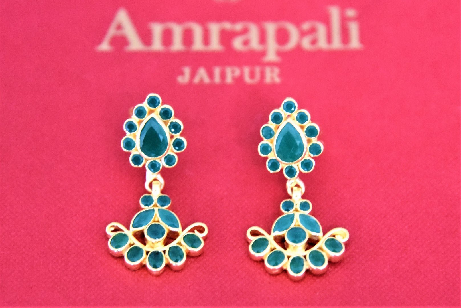 Buy beautiful Amrapali silver gold plated floral earrings online in USA with green stones. Complete your festive look with exclusive silver gold plated jewelry, gold plated earrings, silver jewelry, silver earrings from Pure Elegance Indian fashion store in USA.-flatlay