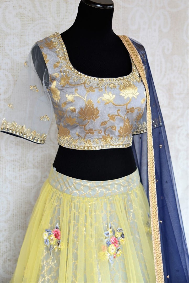 Buy yellow and grey embroidered Banarasi net lehenga with dupatta online in USA . The gorgeous lehenga is a captivating choice for weddings. Shop Indian designer lehengas in USA from an alluring collection available at Pure Elegance clothing store.-side view