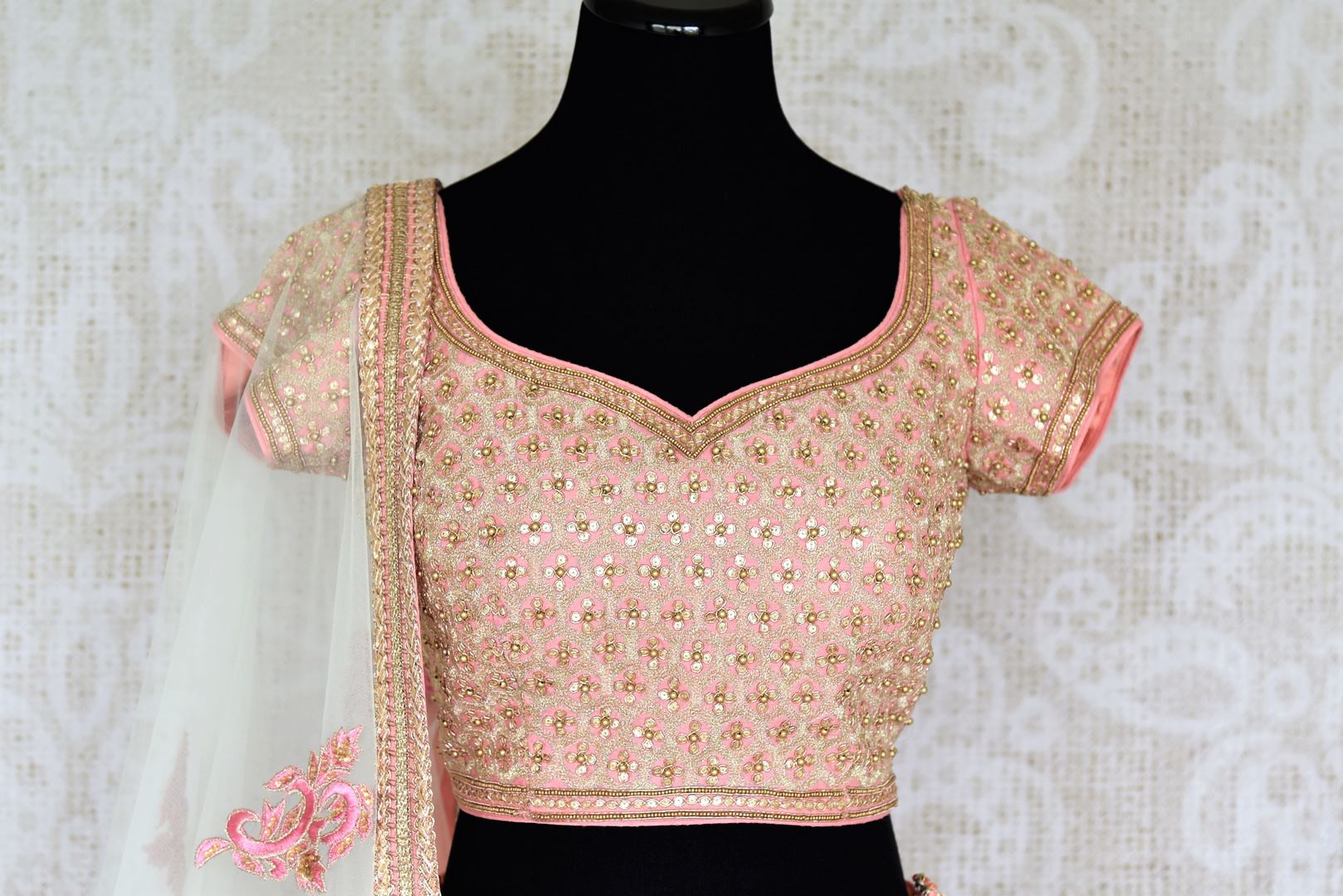 Look no less than a princess in this dreamy soft pink chanderi silk lehenga complemented with a pink zardozi embroidered blouse. A sheer net white embroidered dupatta to complete the look delicately falls on a side. Shop Indian dresses, lehenga choli, anarkali suit online or visit Pure Elegance store, USA.-blouse front