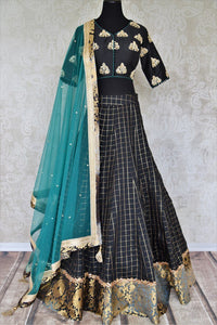 Heavily ornamented royal blue silk lehenga with checkered details and banarsi border comes with a gorgeous blue and beige silk embroidered blouse. Let the teal sequinned net dupatta fall immaculately for the feminine look. Shop designer sarees, lehenga cholis, Indian dresses online or visit Pure Elegance store, USA. -full view