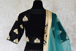 Heavily ornamented royal blue silk lehenga with checkered details and banarsi border comes with a gorgeous blue and beige silk embroidered blouse. Let the teal sequinned net dupatta fall immaculately for the feminine look. Shop designer sarees, lehenga cholis, Indian dresses online or visit Pure Elegance store, USA. -blouse back