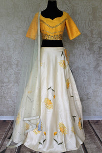 Be an epitome of grace in this designer white raw silk embroidered lehenga. Style this gorgeous lehenga with a mellow yellow embroidered blouse with a sweetheart neckline. Drape a pristine white sequin work laden dupatta. Shop Indian dresses, lehenga cholis, anarkali suits online or visit Pure Elegance store, USA. -full view