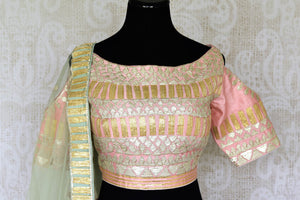 Embrace the pastel drama in this stunning soft pink raw silk lehenga with intricate gota work. It comes with a matching pink gota work raw silk cold shoulder blouse and a beige gota work dupatta. Shop authentic silk sarees, anarkali suits, dress online or visit Pure Elegance store, USA. -blouse pallu