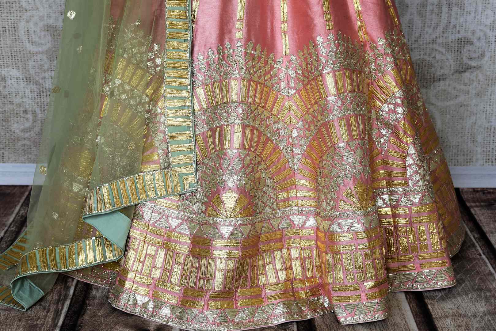 Embrace the pastel drama in this stunning soft pink raw silk lehenga with intricate gota work. It comes with a matching pink gota work raw silk cold shoulder blouse and a beige gota work dupatta. Shop authentic silk sarees, anarkali suits, dress online or visit Pure Elegance store, USA. -lehenga skirt