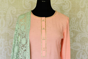 Sashay like a queen in this delicately handcrafted pink chanderi silk long kurta. The sequin work laden kurta is paired well with contrasting mint green skirt and chikankari dupatta to unveil the elegant you. Shop such designer silk sarees, anarkali suits, lehenga sets online or visit Pure Elegance store, USA.-kurta front