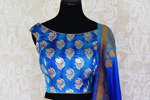 Buy gold Banarasi silk lehenga with blue sleeveless choli online in USA and dupatta. Find a range of stunning designer lehengas in USA at Pure Elegance Indian clothing store. Elevate your traditional style with a range of designer sarees, Indian clothing, and much more also available at our online store.-blouse front