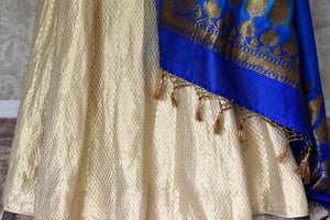 Buy gold Banarasi silk lehenga with blue sleeveless choli online in USA and dupatta. Find a range of stunning designer lehengas in USA at Pure Elegance Indian clothing store. Elevate your traditional style with a range of designer sarees, Indian clothing, and much more also available at our online store.-skirt