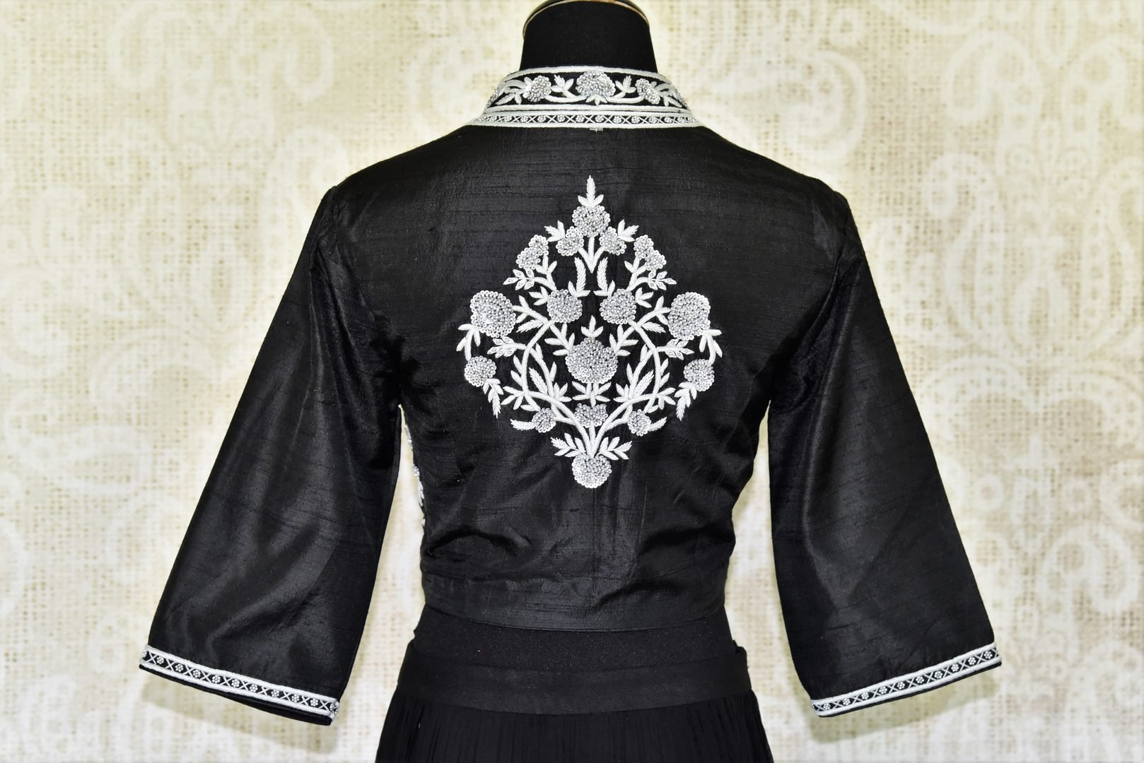 This jaw-dropping black raw silk floor-length skirt is a versatile piece for your wardrobe. Style it right with a hand embroidered floral designer monochrome blouse. Shop designer anarkali suits, kurta sets, lehenga sets online or visit Pure Elegance store, USA. -blouse back