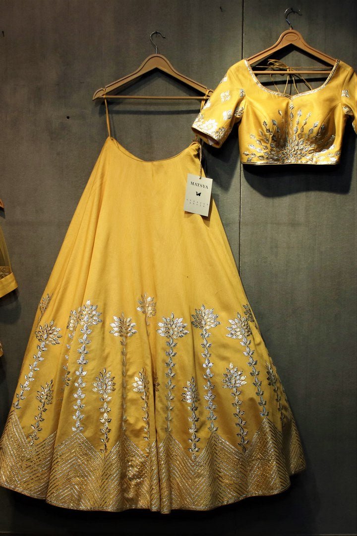 Buy yellow gota patti lehenga with choli online in USA. It comes with a matching dupatta. Find more such exquisite designer lehengas at Pure Elegance online store. You can also give us a visit at our exclusive Indian fashion store in USA and shop from a range of beautiful Indian lehengas, wedding dresses, Anarkalis and much more.-full view