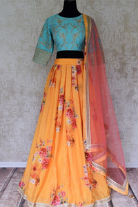Buy yellow floral silk lehenga with blue embroidered blouse online in USA and dupatta. Find a range of stunning designer lehengas in USA at Pure Elegance Indian clothing store. Elevate your traditional style with a range of designer saris, Indian clothing, and much more also available at our online store.-full view
