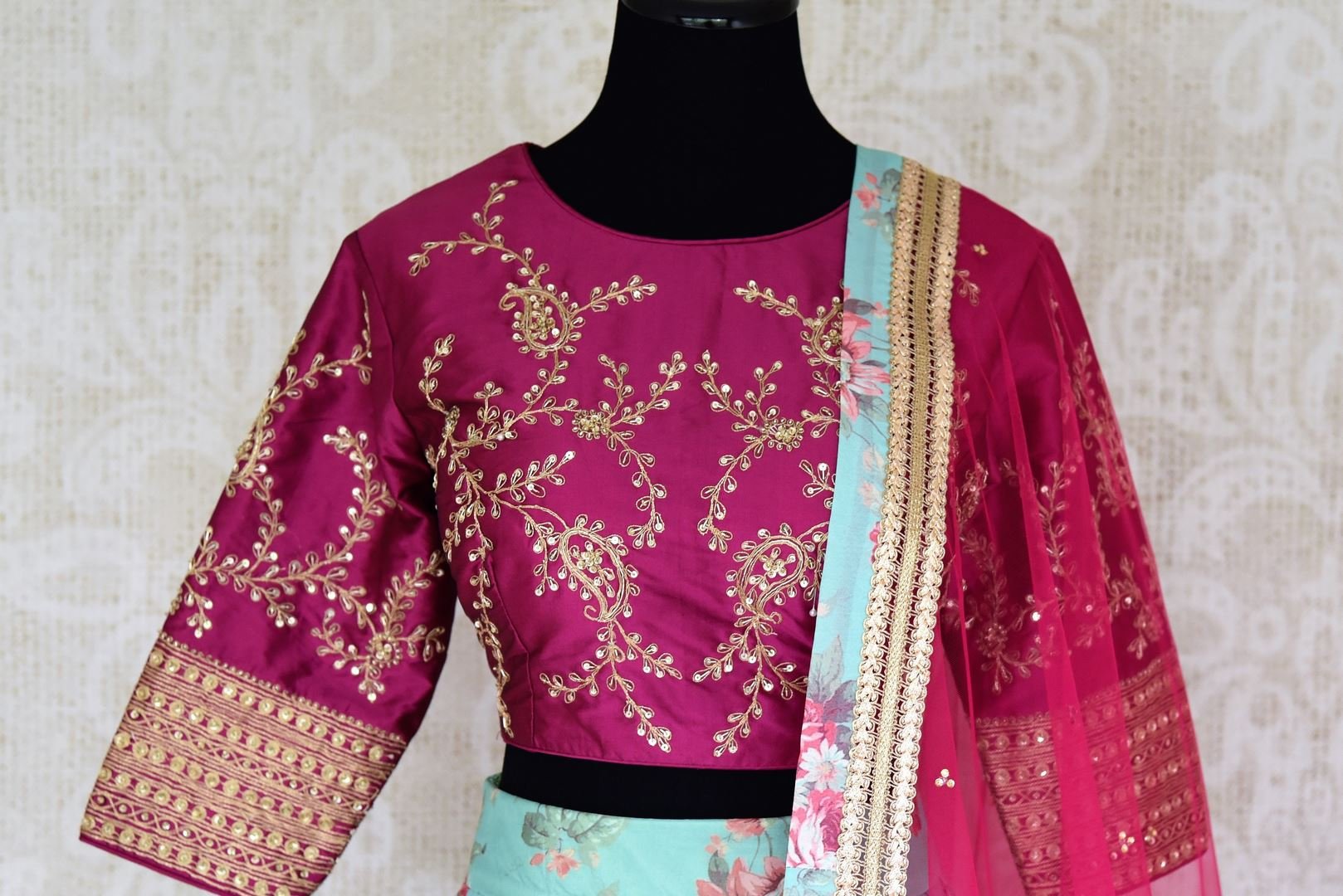 Shop blue floral silk lehenga with magenta embroidered blouse online in USA and dupatta. Find a range of stunning designer lehengas in USA at Pure Elegance Indian clothing store. Elevate your traditional style with a range of designer saris, Indian clothing, and much more also available at our online store.-blouse front
