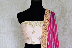 Shop off-white embroidered Banarasi lehenga online in USA with pink dupatta. Get ready to dazzle on weddings and special occasions with an exquisite variety of Indian designer clothes from Pure Elegance Indian clothing store in USA. We have a splendid collection of bridal lehengas, designer sarees, Anarkali suits to make your look absolutely one of kind.-front