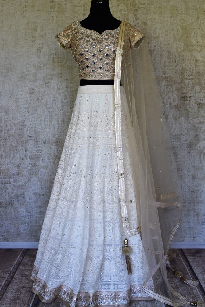 Shop off-white Lucknowi lehenga with silk blouse online in USA and net dupatta. Get ready to dazzle on weddings and special occasions with an exquisite variety of Indian designer clothes from Pure Elegance Indian clothing store in USA. We have a splendid collection of bridal lehengas, designer sarees, Anarkali suits to make your look absolutely one of kind.-full view