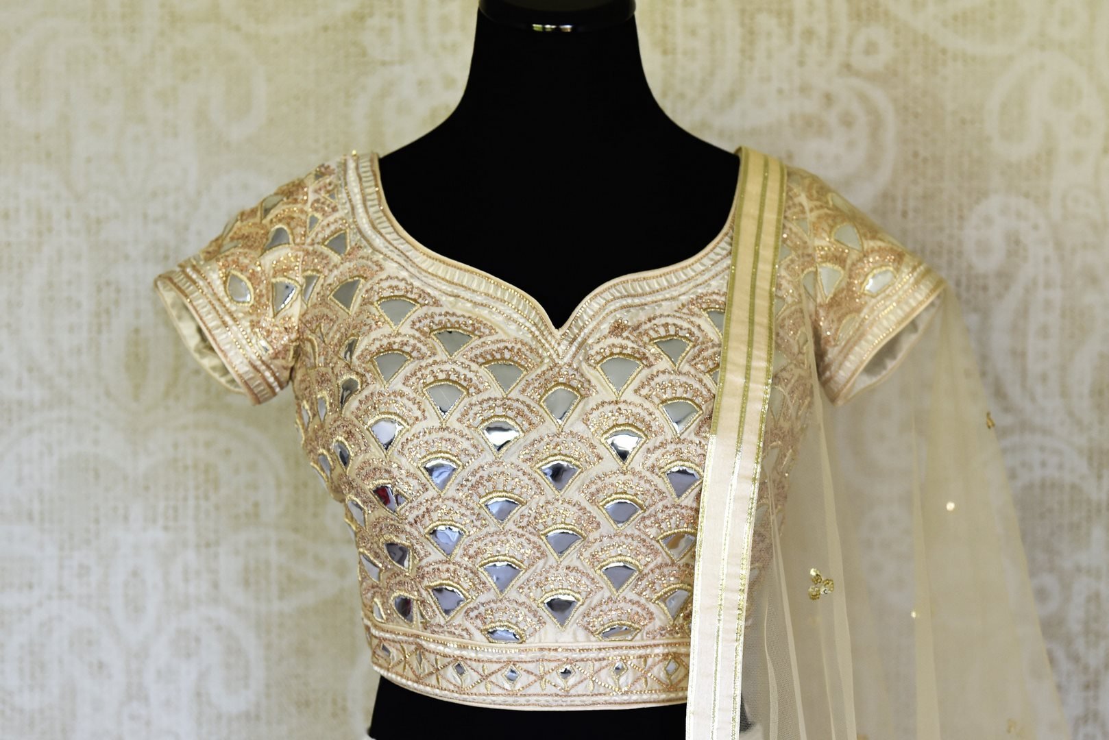 Shop off-white Lucknowi lehenga with silk blouse online in USA and net dupatta. Get ready to dazzle on weddings and special occasions with an exquisite variety of Indian designer clothes from Pure Elegance Indian clothing store in USA. We have a splendid collection of bridal lehengas, designer sarees, Anarkali suits to make your look absolutely one of kind.-front
