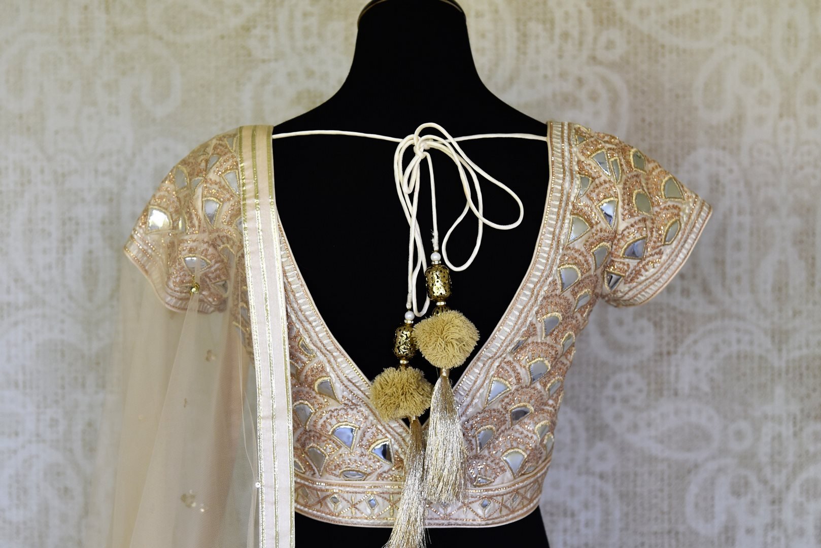 Shop off-white Lucknowi lehenga with silk blouse online in USA and net dupatta. Get ready to dazzle on weddings and special occasions with an exquisite variety of Indian designer clothes from Pure Elegance Indian clothing store in USA. We have a splendid collection of bridal lehengas, designer sarees, Anarkali suits to make your look absolutely one of kind.-back