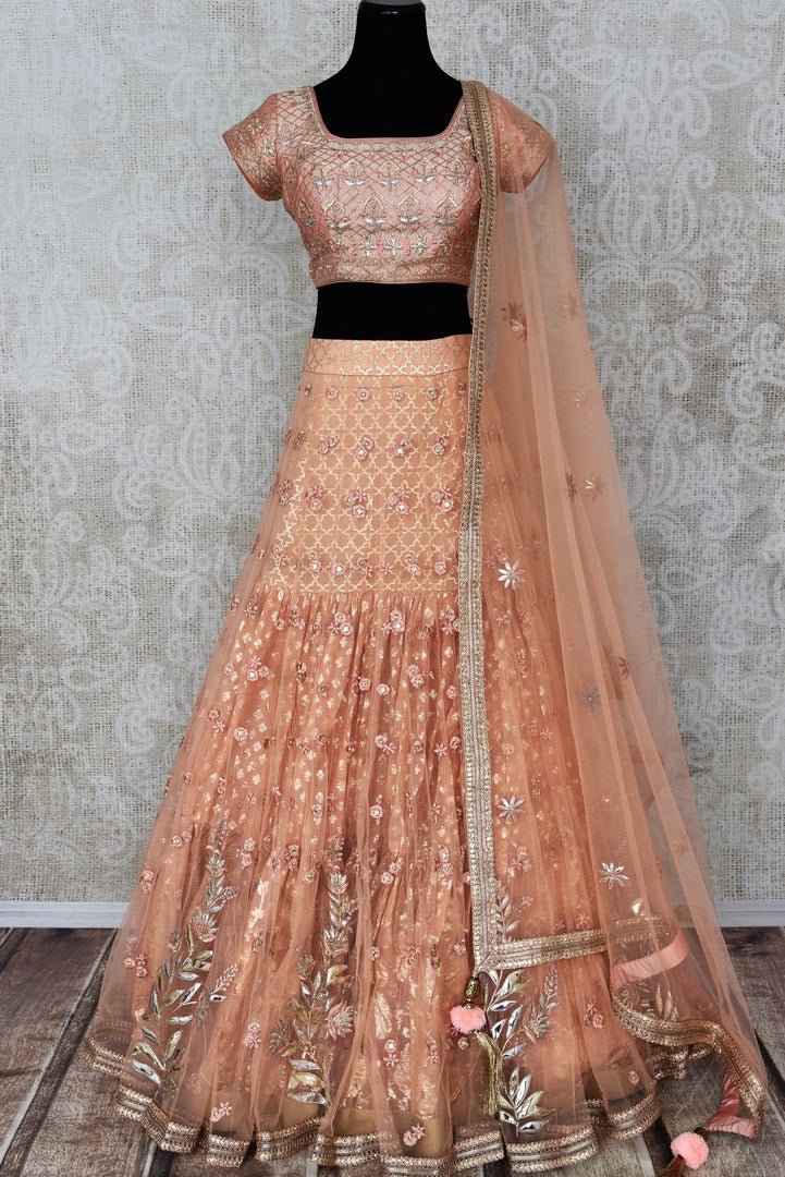 Buy peach net and silk embroidered lehenga online in USA with dupatta. Pick your favorite Indian clothing from a colorful collection available at Pure Elegance Indian fashion store in USA. We have an alluring range of wedding lehengas, designer Anarkali suits, gowns for Indian women in USA.-full view