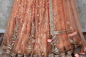 Buy peach net and silk embroidered lehenga online in USA with dupatta. Pick your favorite Indian clothing from a colorful collection available at Pure Elegance Indian fashion store in USA. We have an alluring range of wedding lehengas, designer Anarkali suits, gowns for Indian women in USA.-skirt