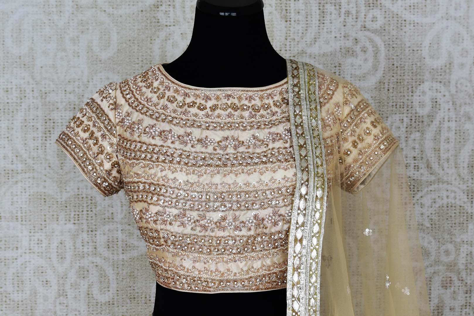 Shop off-white embroidered Lucknowi lehenga online in USA with dupatta. Pick your favorite Indian clothing from a colorful collection available at Pure Elegance Indian fashion store in USA. We have an alluring range of wedding lehengas, designer Anarkali suits, gowns for Indian women in USA.-front