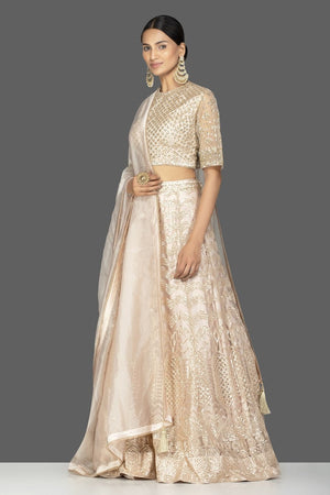 Shop beautiful cream embroidered net lehenga online in USA with dupatta. Gear up for the festive season with exquisite designer lehengas, Anarkali suits. Indian dresses from Pure Elegance Indian fashion store in USA. Shop online now.-side