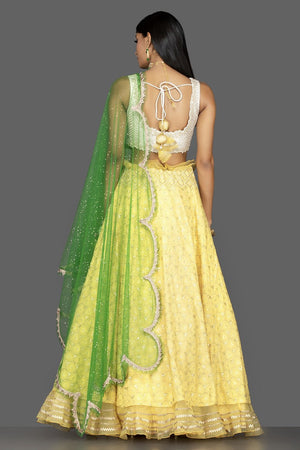 Shop beautiful yellow and off-white Lucknowi work georgette lehenga online in USA with green net dupatta. Look radiant on weddings and special occasions in splendid designer lehengas crafted with finest embroideries and stunning silhouettes from Pure Elegance Indian fashion boutique in USA.-back