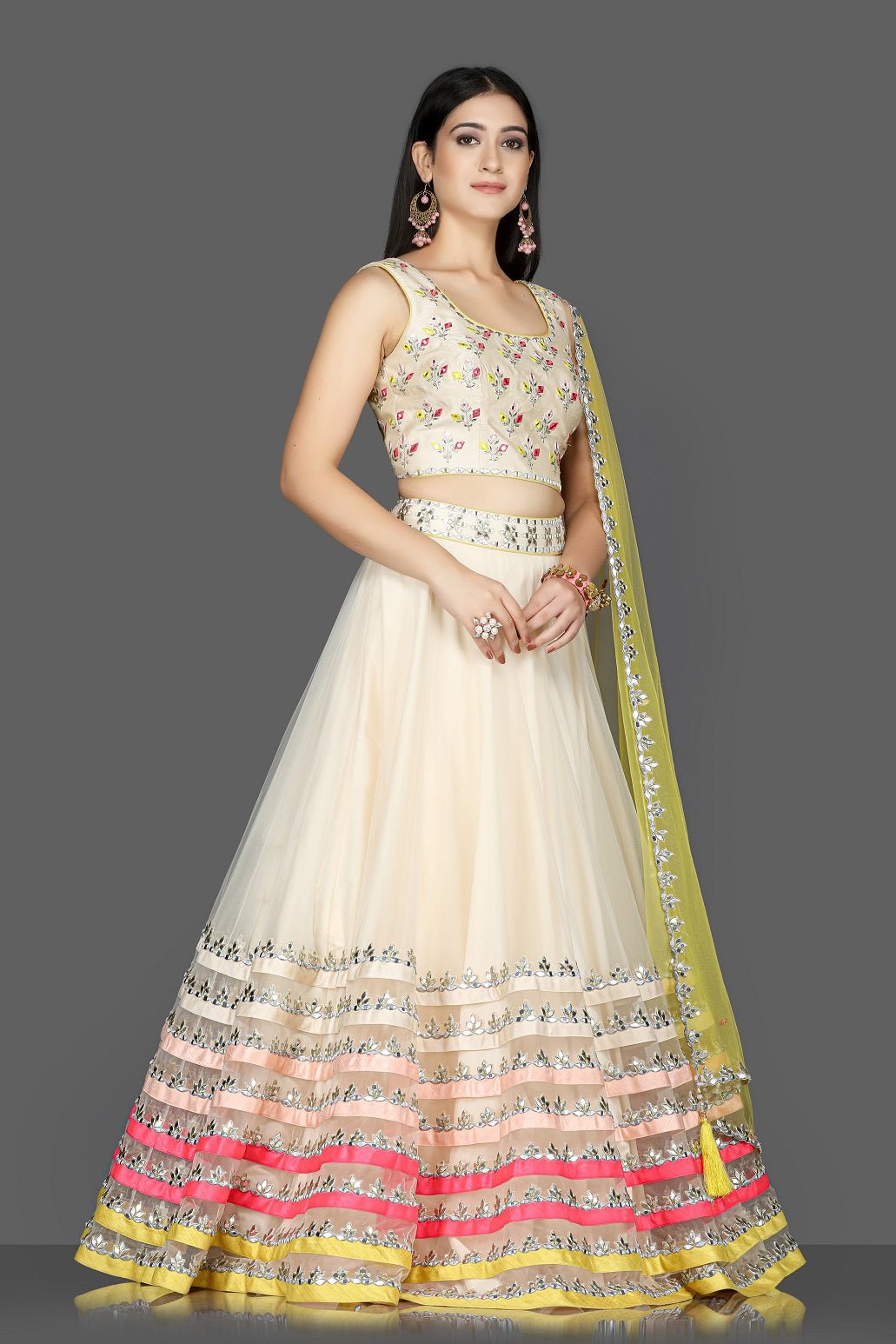 Shop cream embroidered net and raw silk lehenga online in USA with yellow dupatta. Flaunt ethnic fashion with exquisite designer lehenga, Indian wedding dresses from Pure Elegance Indian fashion boutique in USA.-side