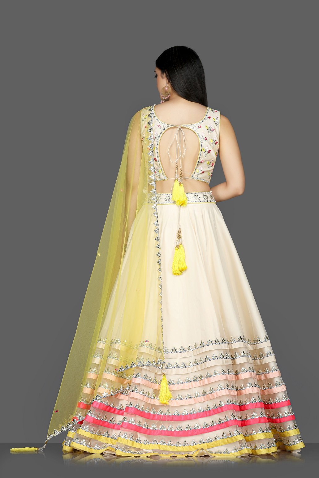 Shop cream embroidered net and raw silk lehenga online in USA with yellow dupatta. Flaunt ethnic fashion with exquisite designer lehenga, Indian wedding dresses from Pure Elegance Indian fashion boutique in USA.-back