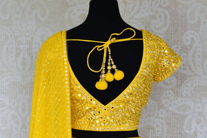 Shop stunning yellow mirror work net and georgette lehenga online in USA. Be occasion ready in stunning designer dresses, lehengas, palazzo suits, sharara suits, bridal lehengas from Pure Elegance Indian clothing store in USA.-back