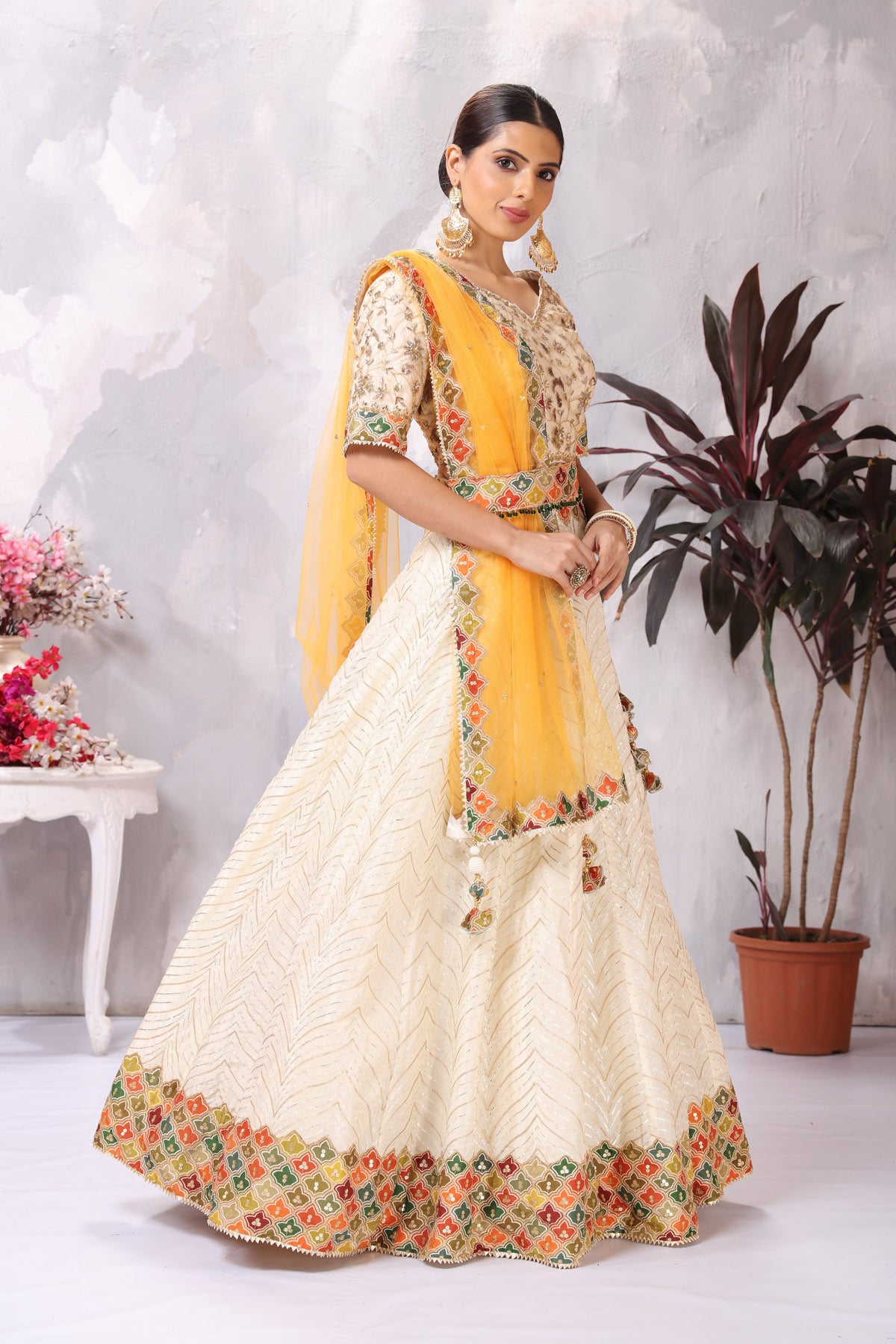 Shop gorgeous off-white embroidered belted designer lehenga online in USA. Be the center of attraction on special occasion in beautiful designer lehengas, bridal lehengas, palazzo suits, sharara suits, Anarkali suits, gowns from Pure Elegance Indian fashion store in USA.-side