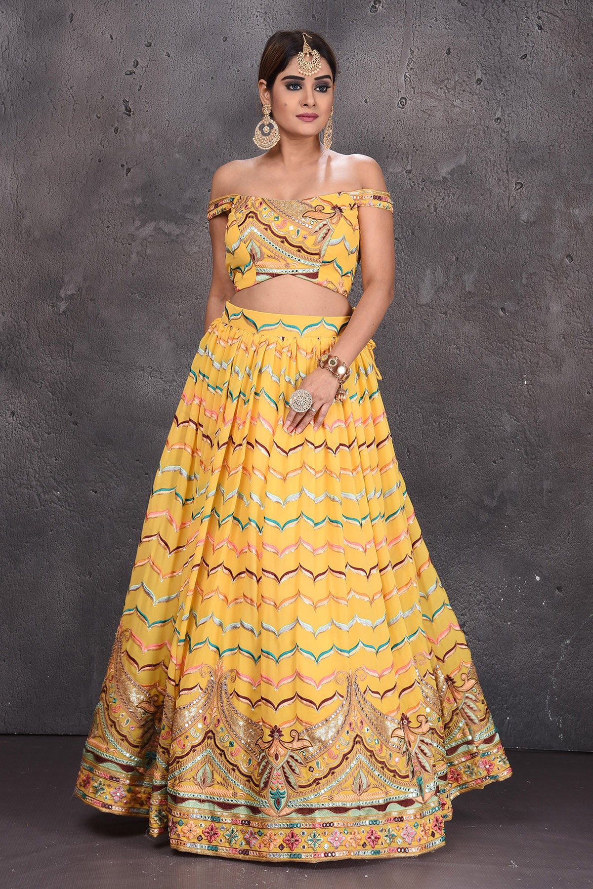 Buy stunning yellow embroidered off-shoulder designer lehenga online in USA with dupatta. Radiate ethnic glam on special occasions in beautiful designer lehengas, Anarkali suits, Indowestern dresses, designer gown, salwar suits from Pure Elegance Indian fashion store in USA,-front